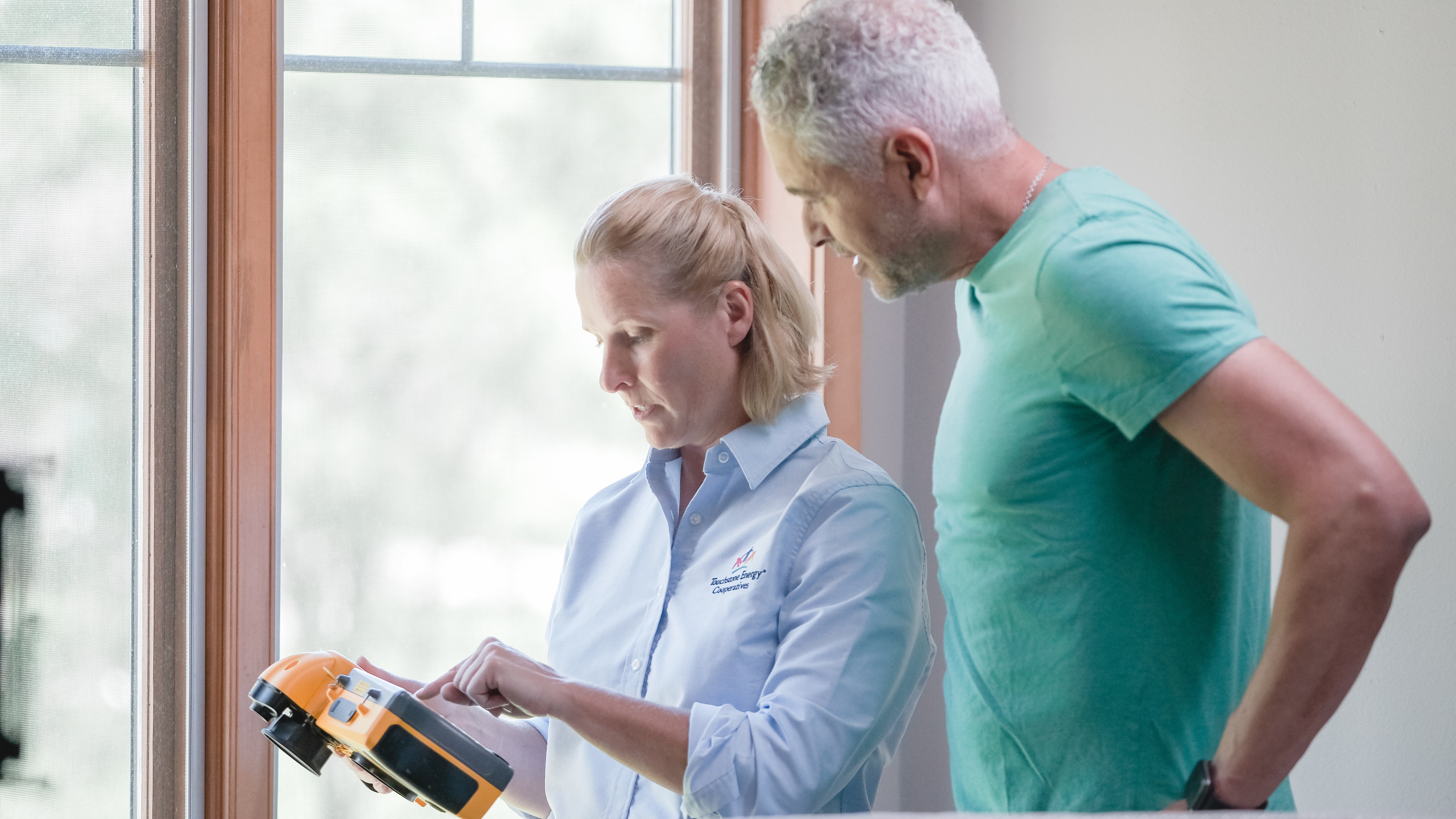 man and woman inside performing a home energy audit