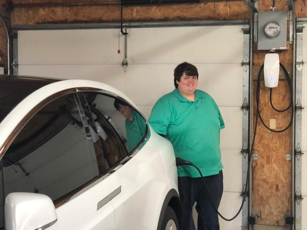 Member Craig Hart with his Tesla X electric vehicle and charging station Midwest Electric helped install